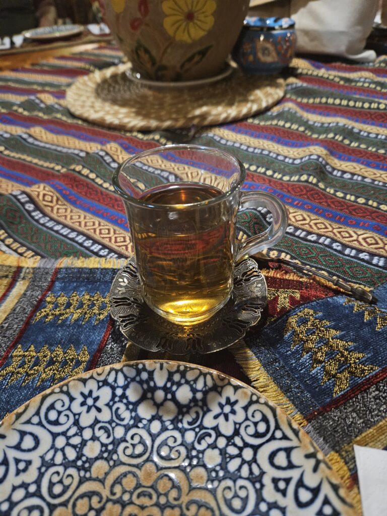 Traditional Turkish breakfast table with shared plates of cheese, olives, bread, and tea.