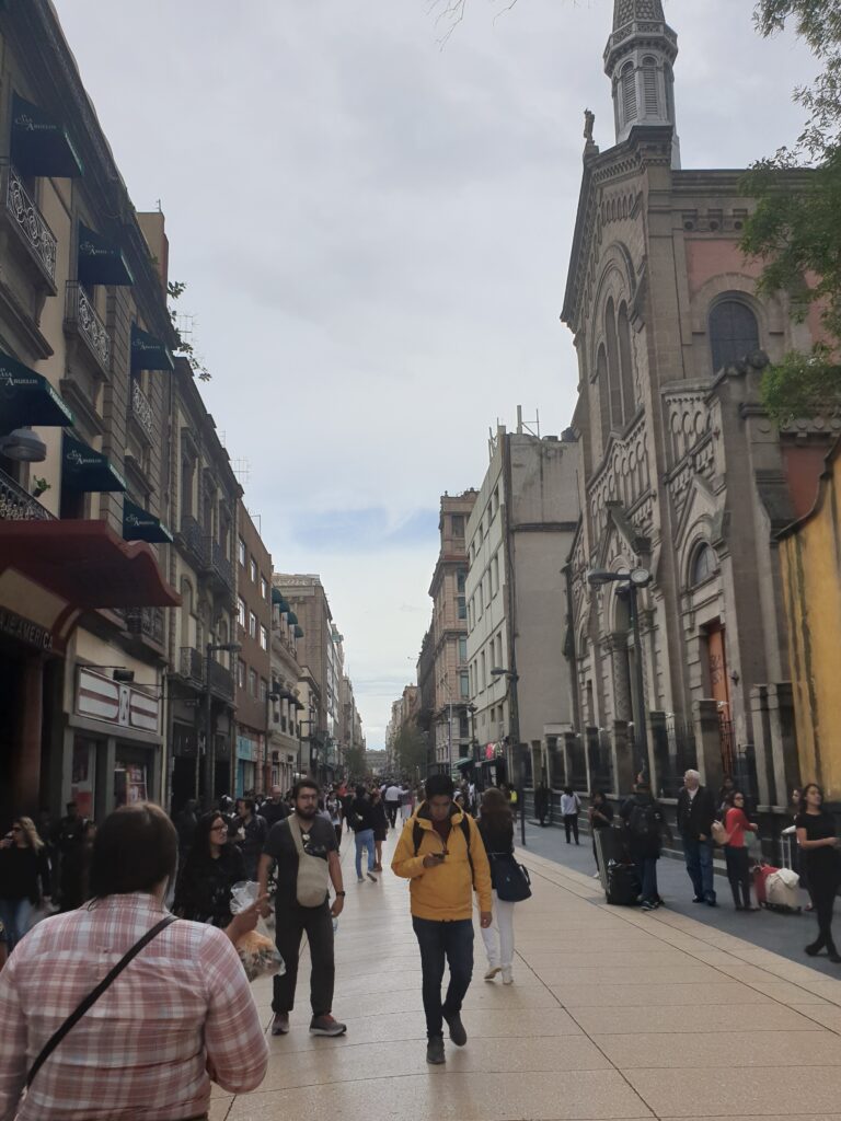 Busy pedestrian street in Centro Histórico with people walking and buildings on both sides.