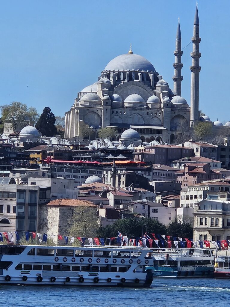 Istanbul skyline with mosque and ferries crossing the Bosphorus.