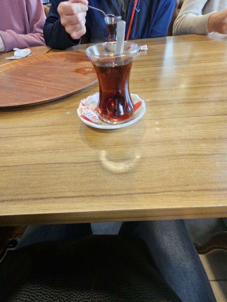 Turkish tea served in a tulip-shaped glass at a shared table in Istanbul.